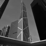 Black and white photo of towering skyscrapers in Hong Kong showcasing modern architecture.